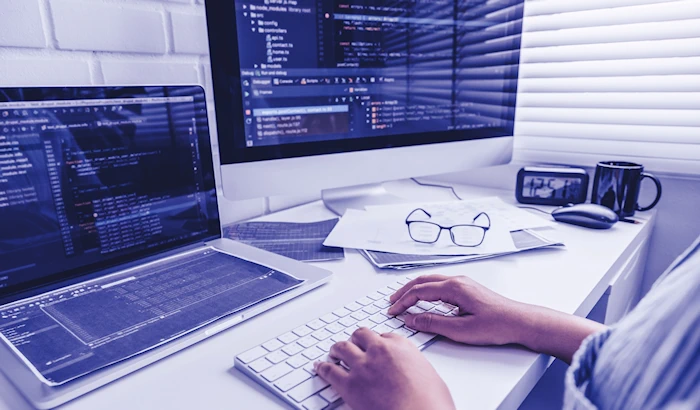 Desk showing multiple screens with development code